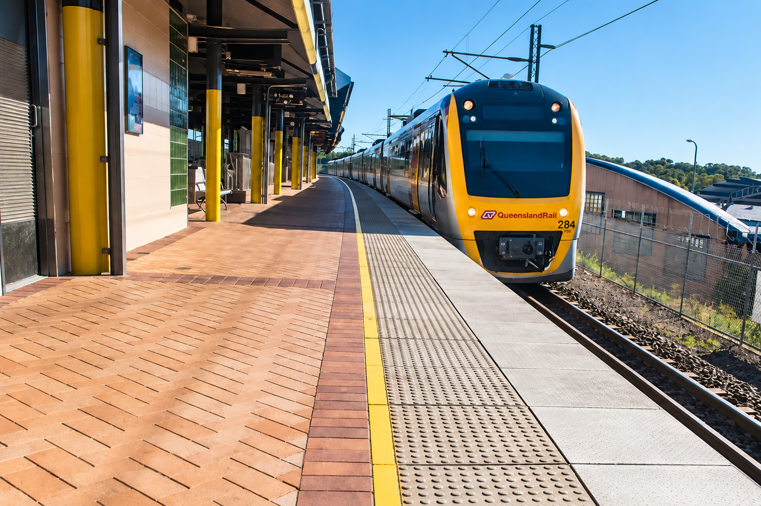 Queensland Rail passenger train stopped at a Gold Coast station platform
