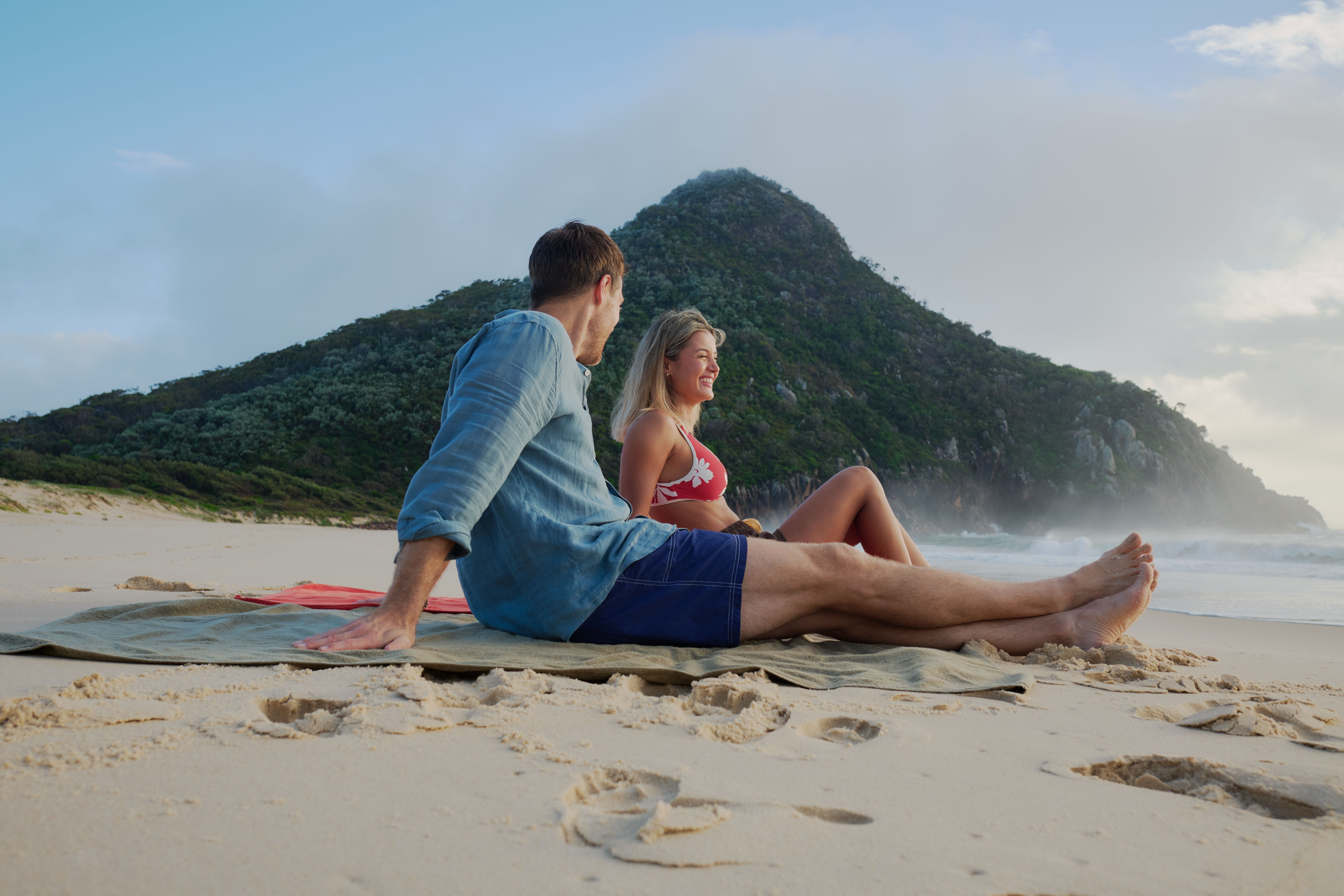Couple explores Zenith Beach, Port Stephens. A secluded 400-meter crescent of pristine white sand in Tomaree National Park