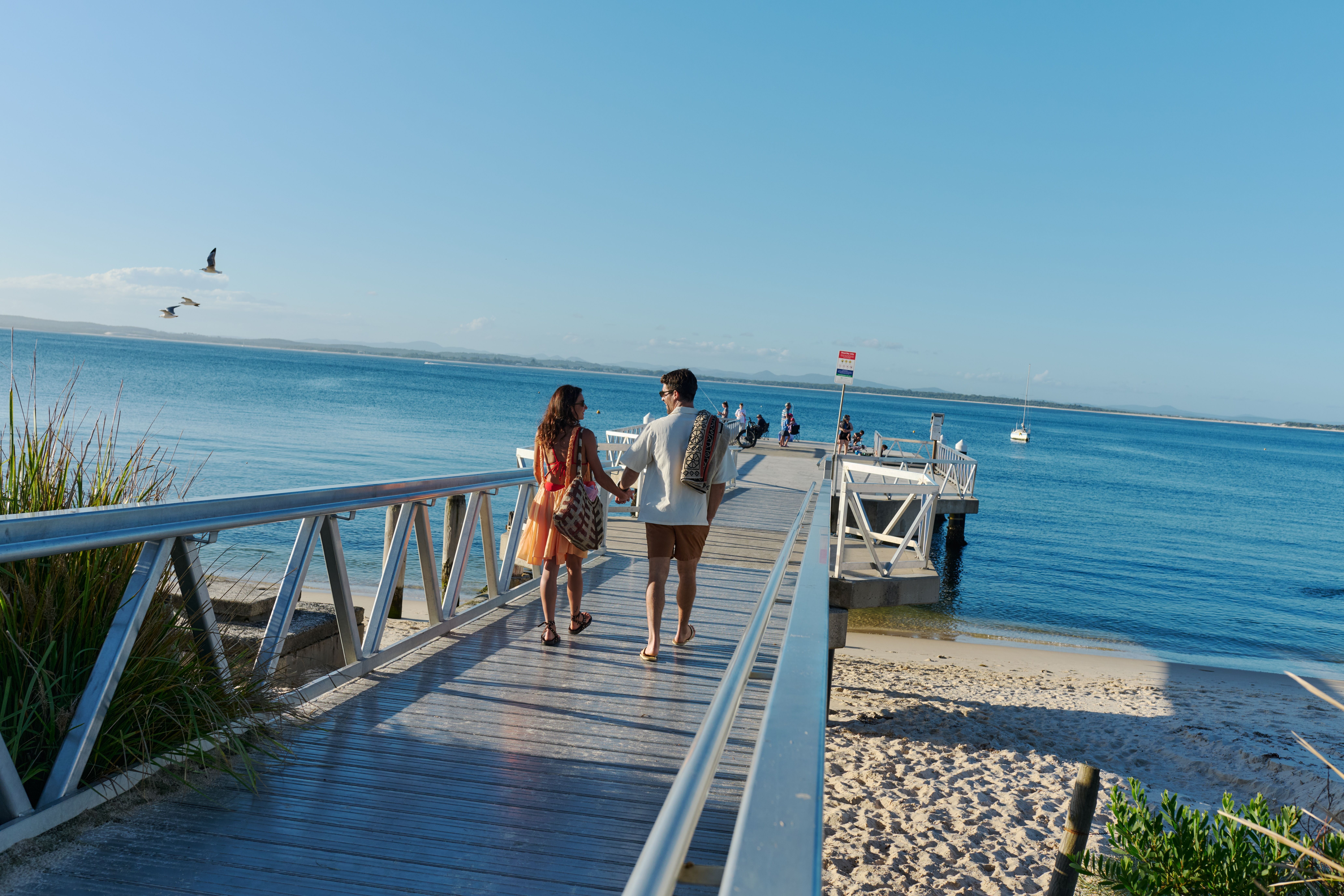 Couple enjoying the views from Shoal Bay Wharf in Port Stephens.