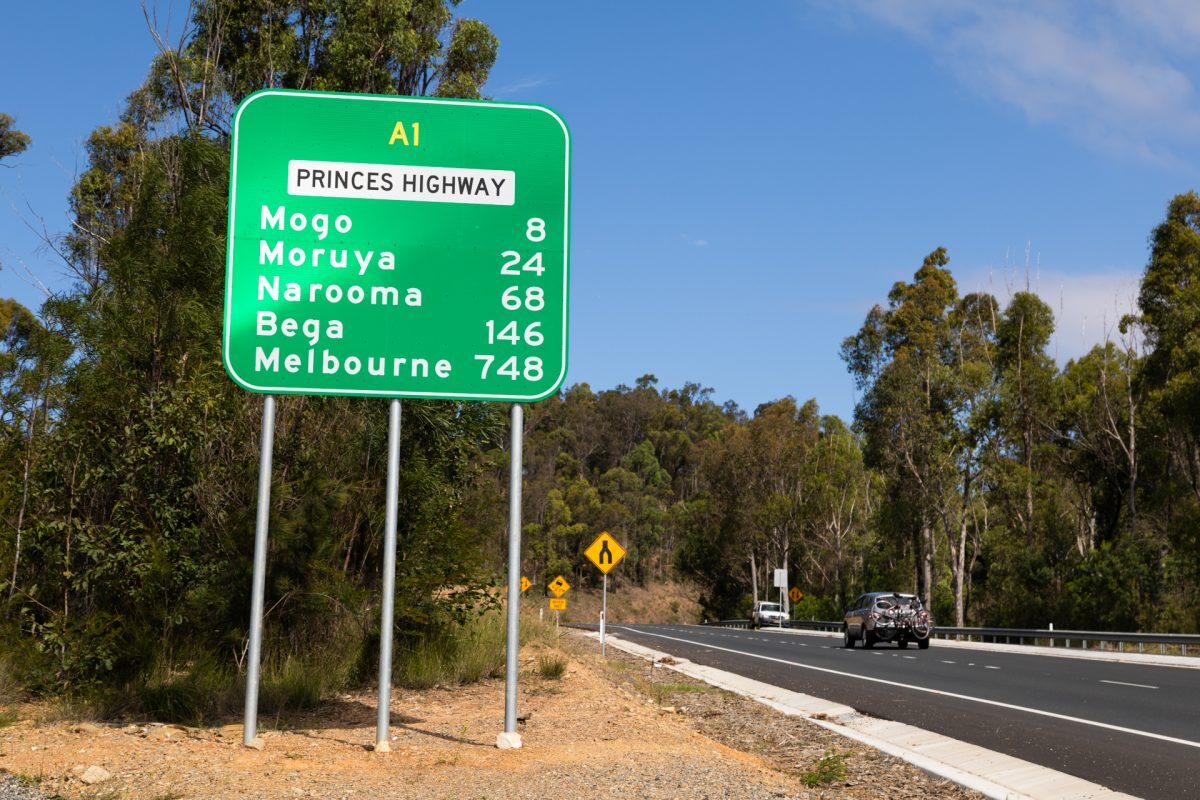 Princes Highway road sign showing distances to Mogo, Moruya, Narooma, Bega and Melbourne.