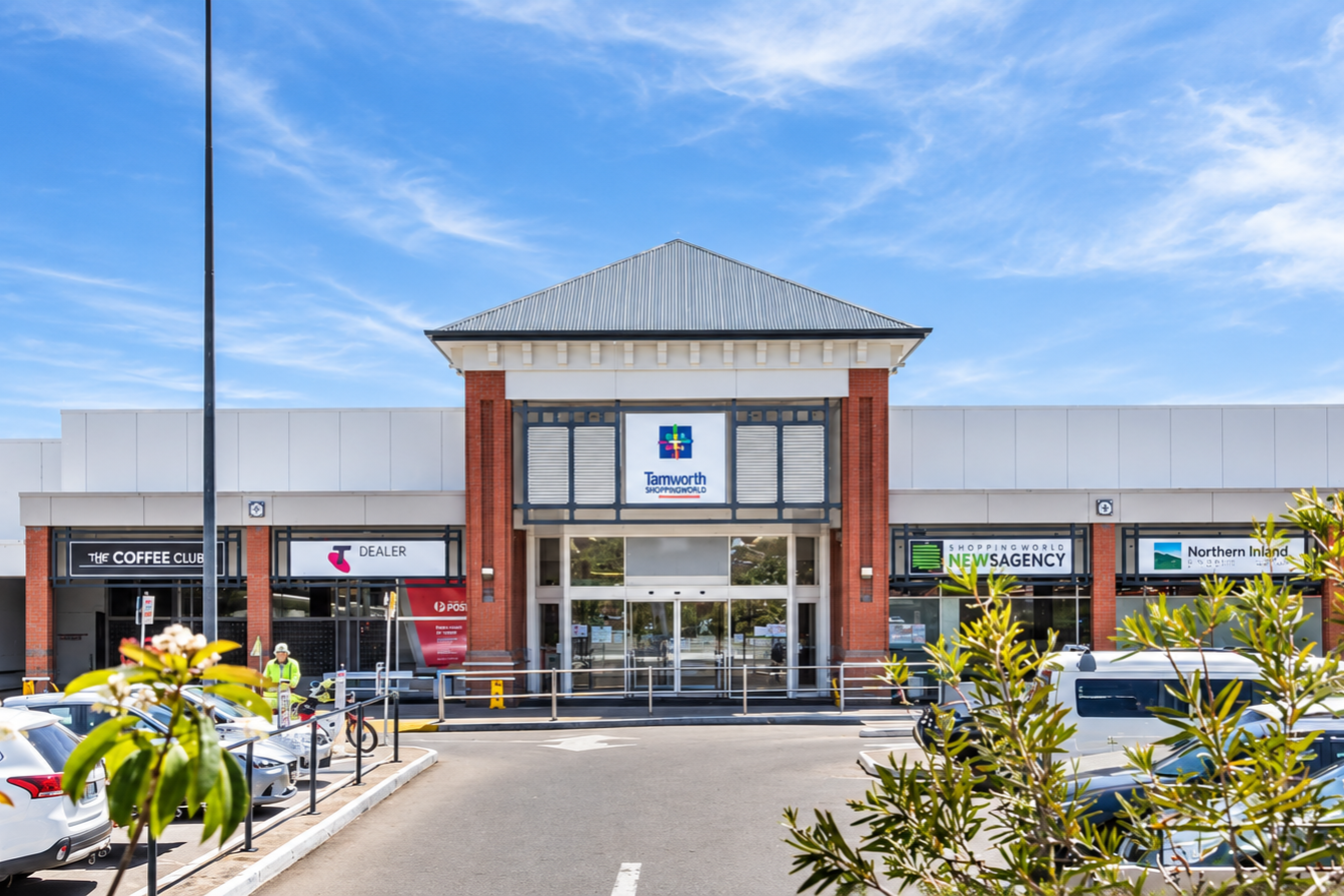Main entrance of Tamworth Shoppingworld with surrounding shops and parked cars.