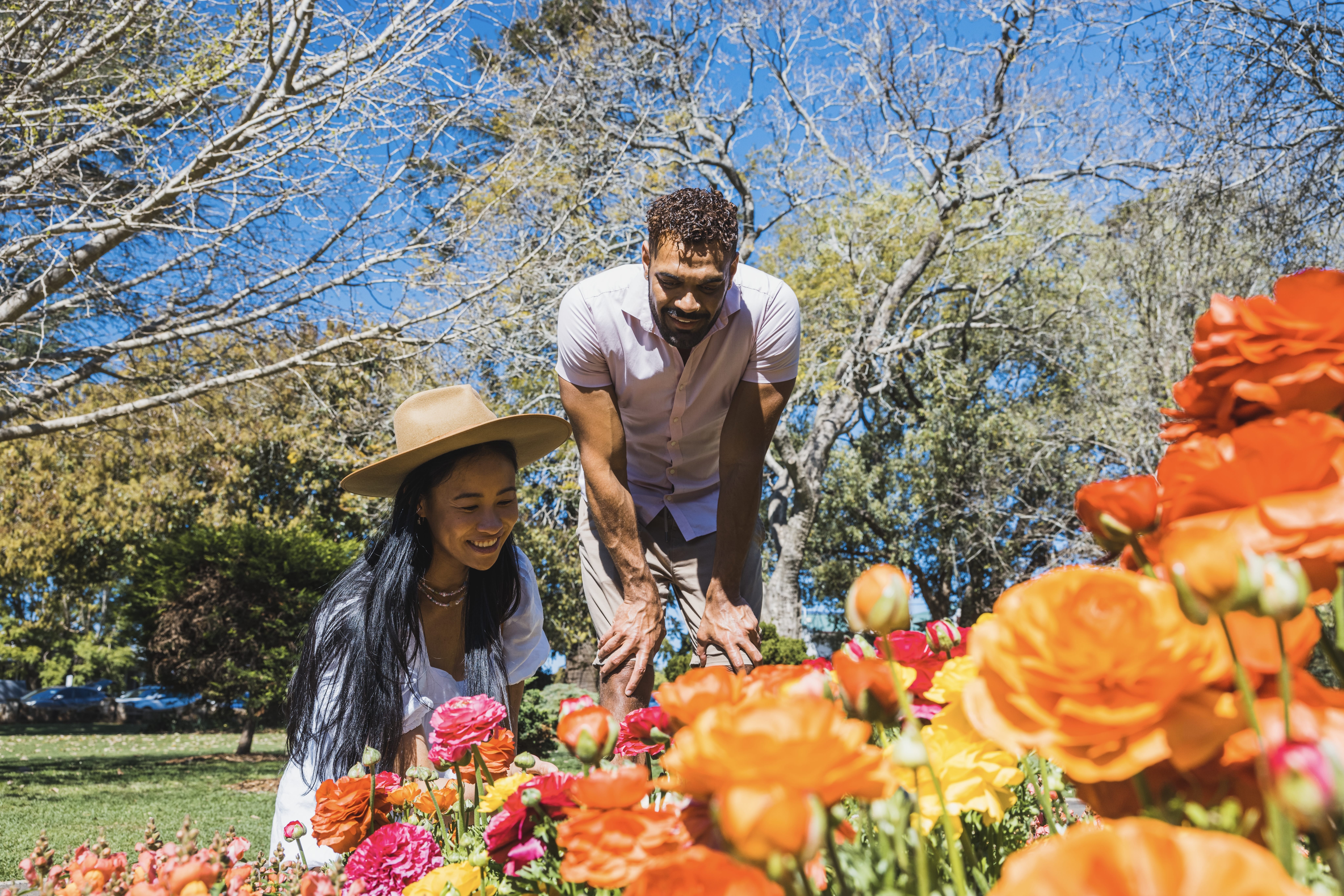 Couple looking at flowers in Queens Park.