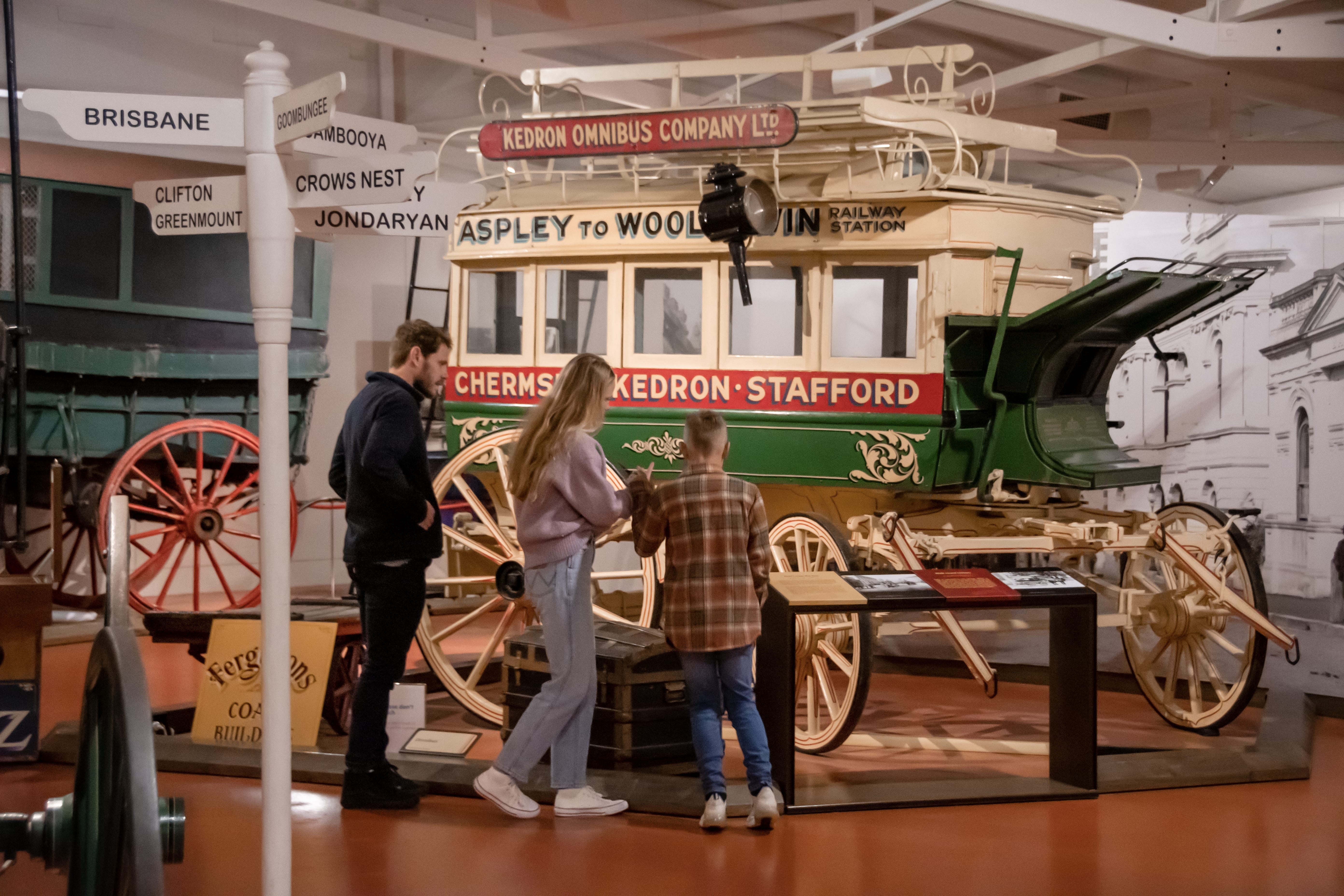 Family looking at an old stage coach at the Cobb+Co Museum.
