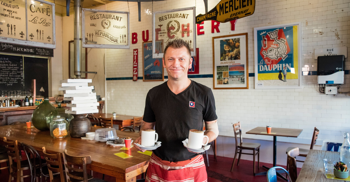 Waiter with coffees at Butcher Shop Cafe, Mudgee.