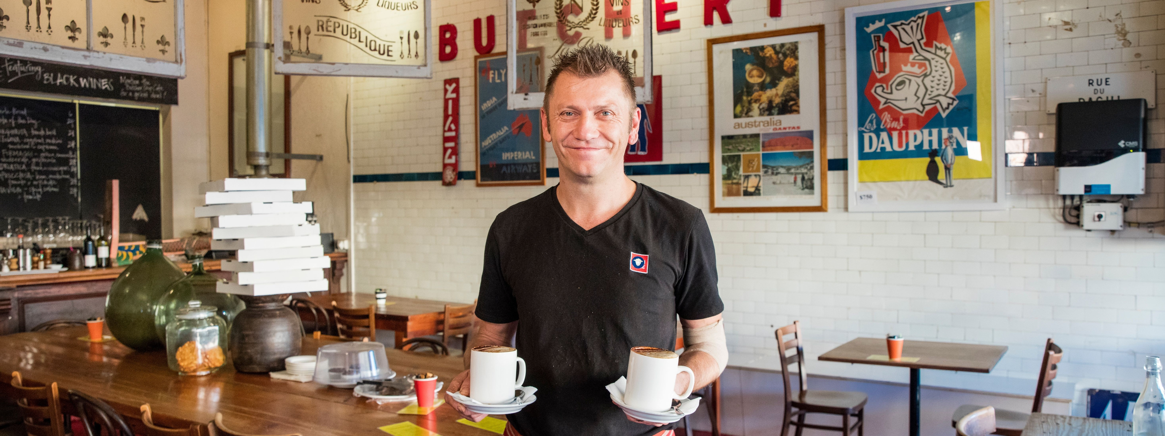 Waiter with coffees at Butcher Shop Cafe, Mudgee.